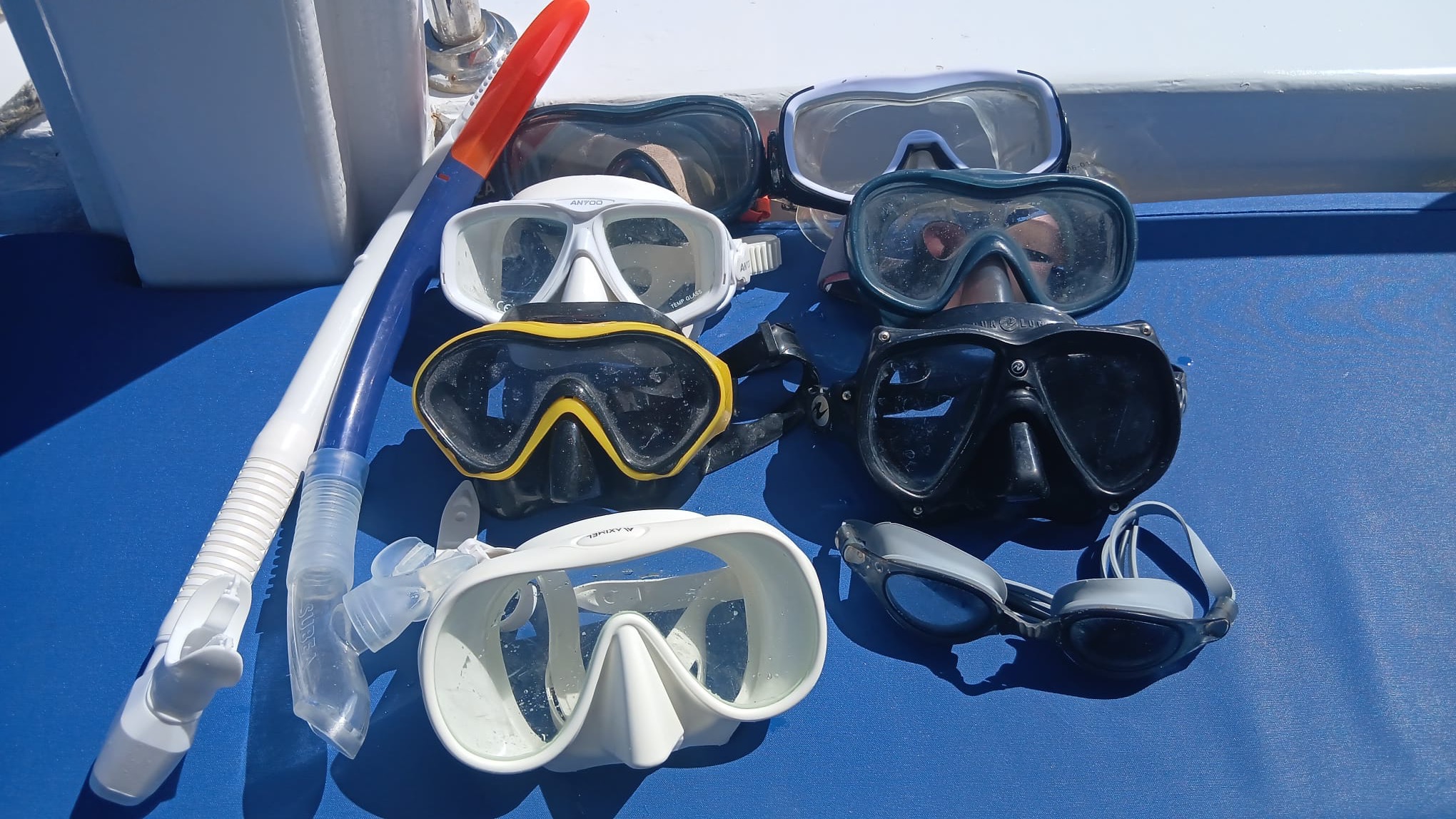 Snorkelling masks and snorkels laid out on deck, in adult and child sizes
